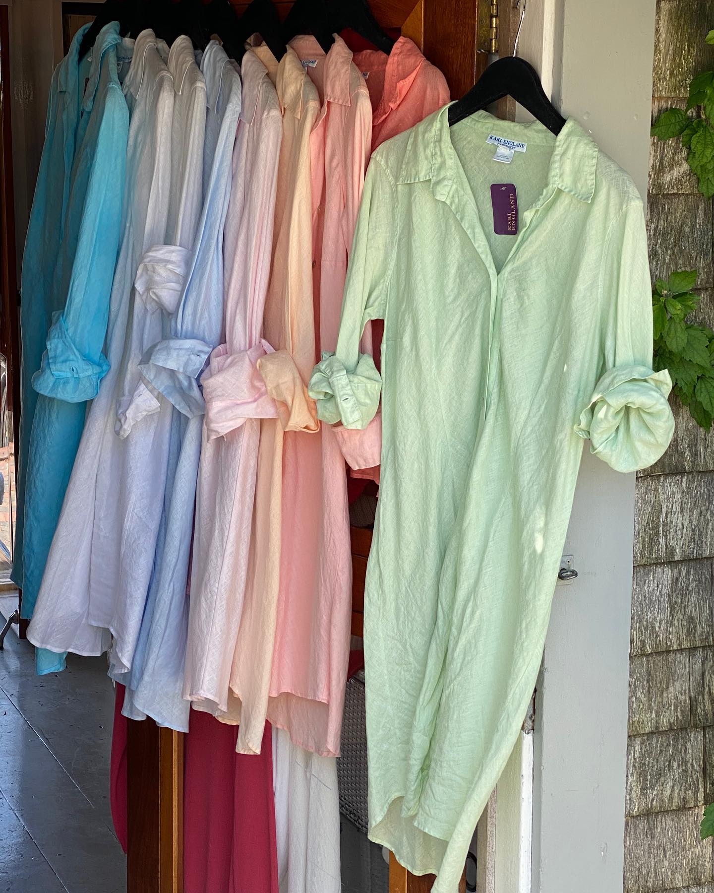 A rack of hand-dyed linen shirtdresses in aqua, blue, pink, peach and lime
